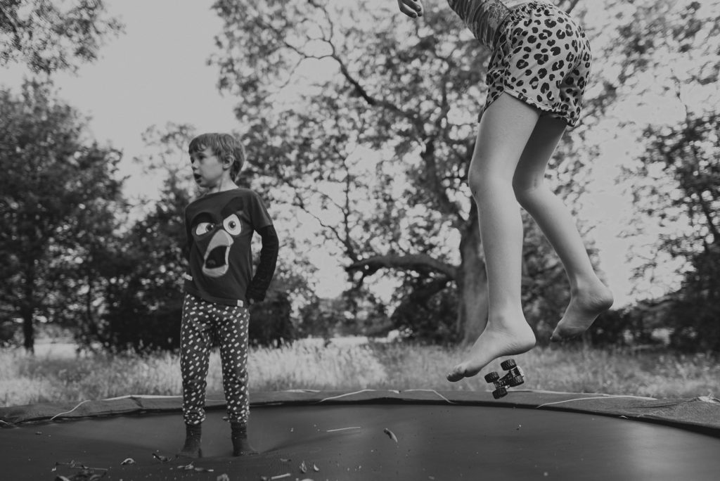 two kids jumping on a trampoline